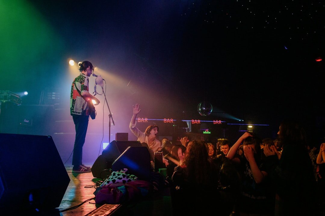 Concert crowd with colorful stage lights and a singer on stage